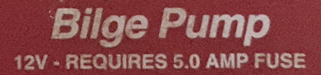 Closeup of the top of the bilge pump, which reads: BILGE PUMP: 12V - REQUIRES 5.0 AMP FUSE