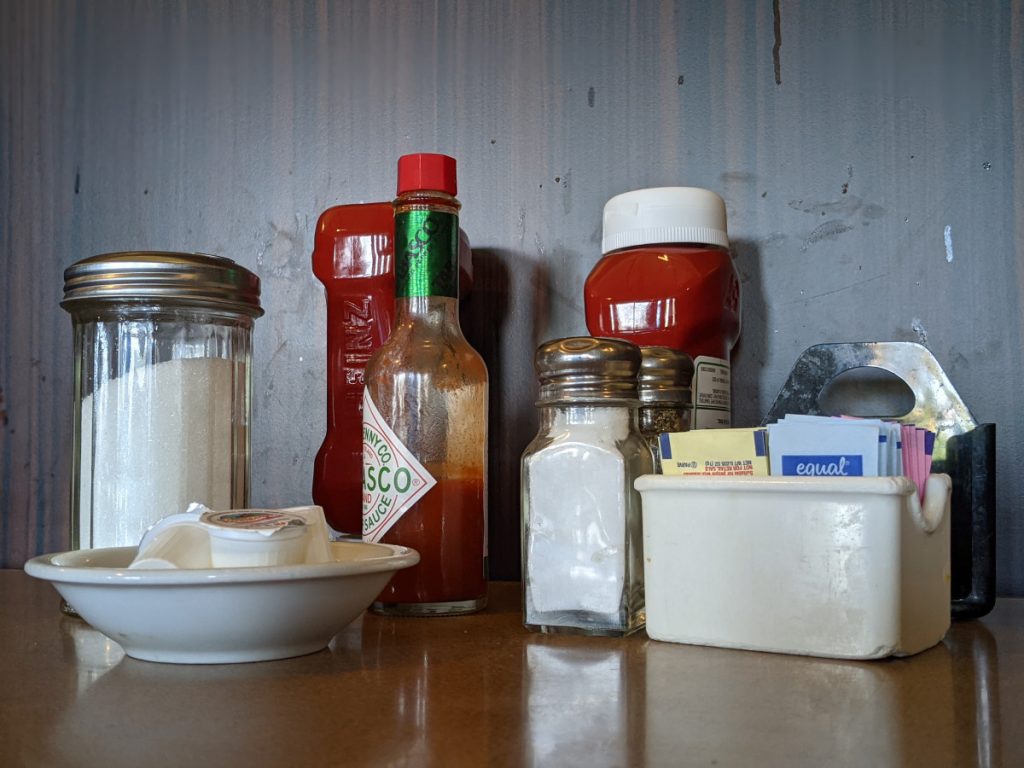 Condiments in front of Dirty Wood Paneling